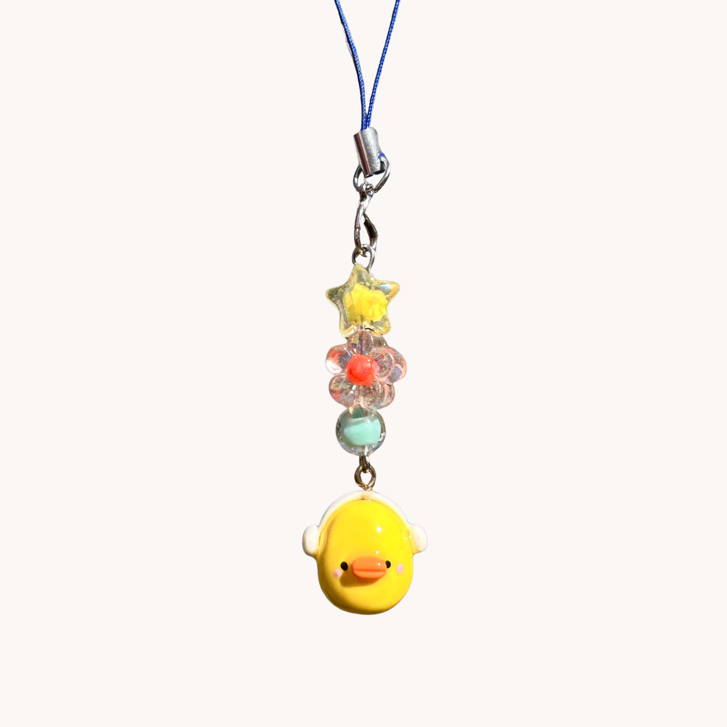 Yellow duck charm with headphones with colorful beads on a white