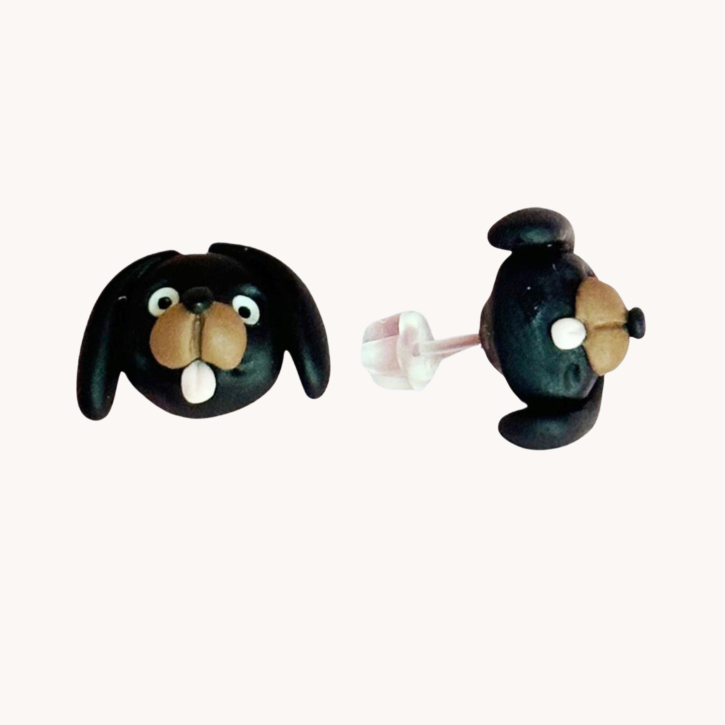 Pair of handmade polymer clay dachshund shaped earrings on a white background