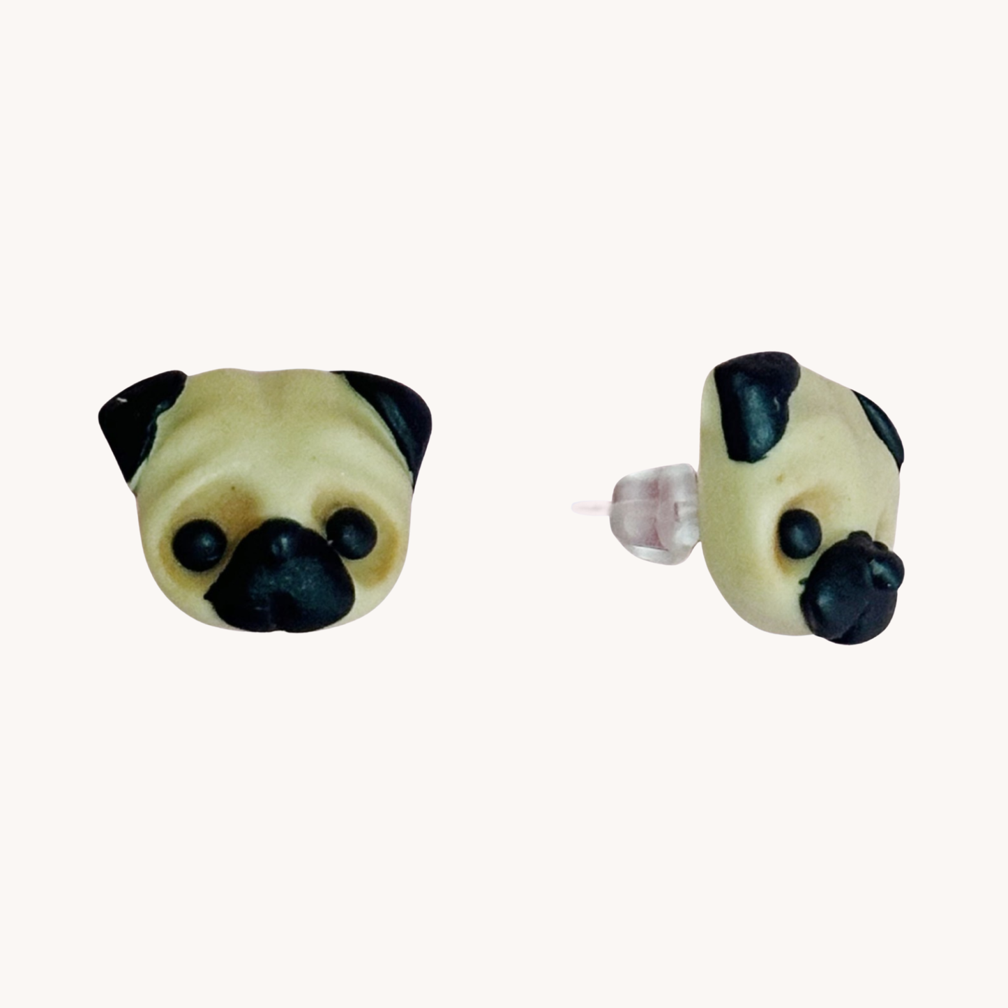 Two handmade polymer clay pug shaped earrings on a white background
