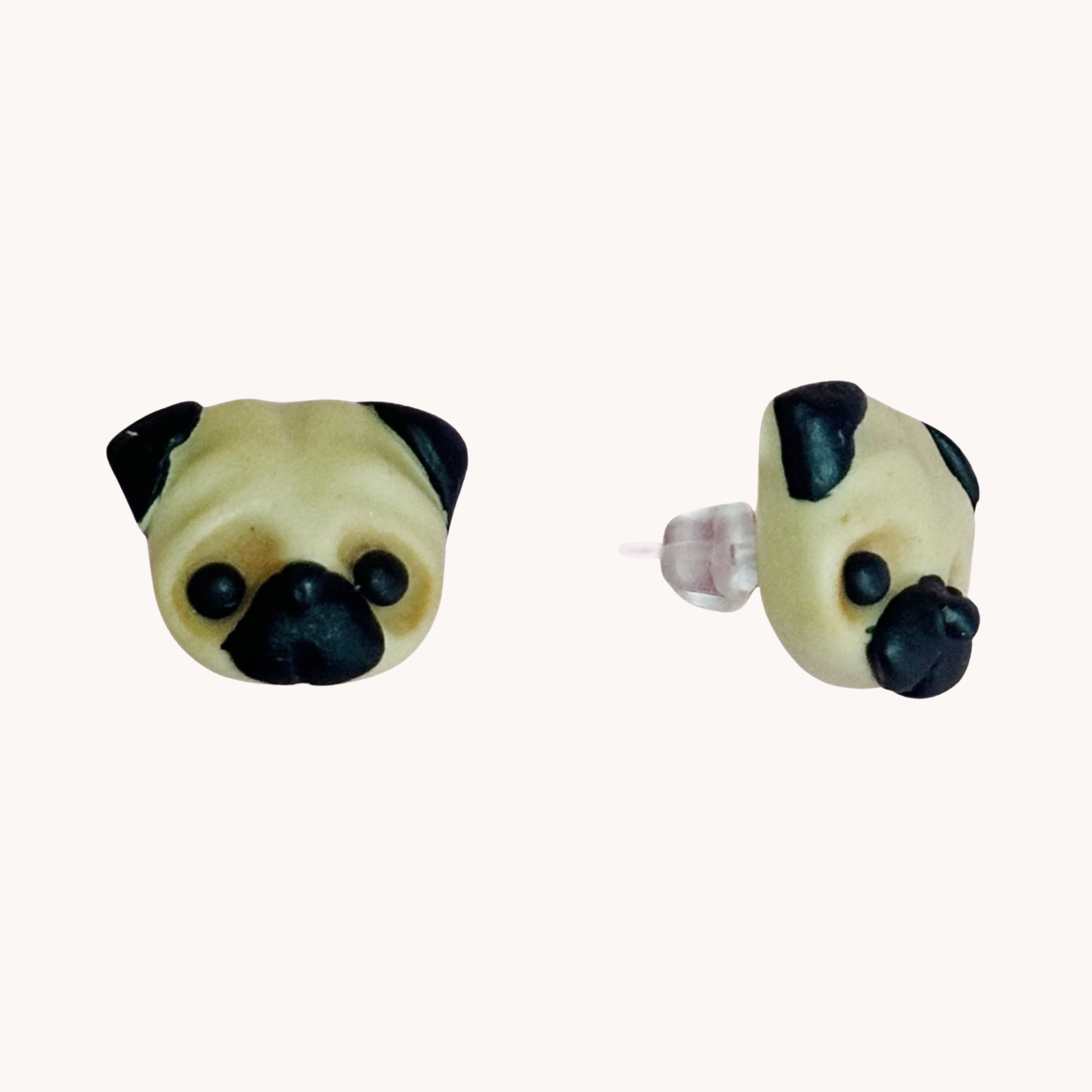 Two handmade polymer clay pug shaped earrings on a white background