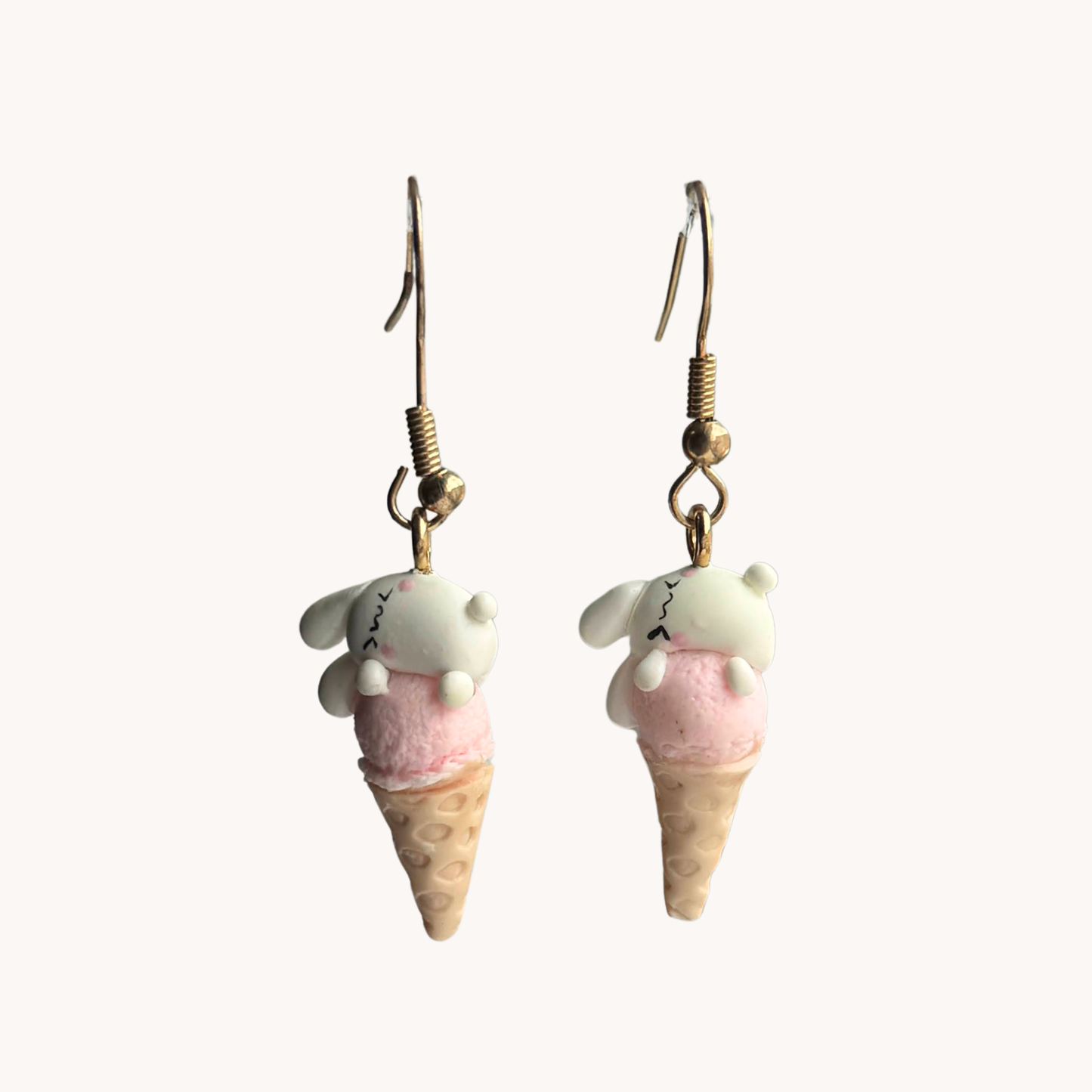 Ice cream cone earrings with pink and bunny tops on a white background
