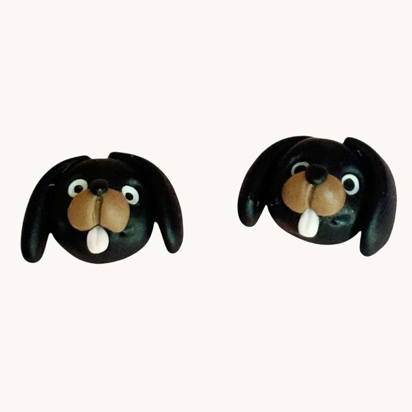 Pair of handmade polymer clay dachshund shaped earrings on a white background