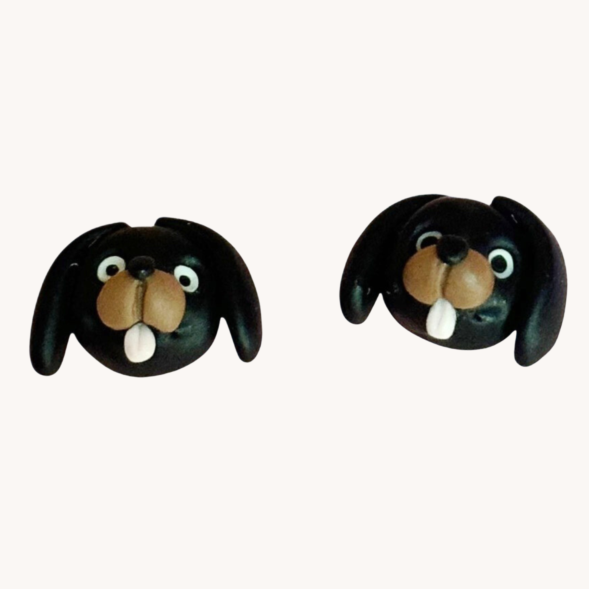 Pair of handmade polymer clay dachshund shaped earrings on a white background
